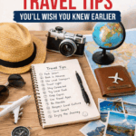 Flat lay of travel essentials with notebook showing 12 genius travel tips, passport, camera, map and planning setup