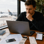 Hidden travel costs shown as a traveller reviews unexpected travel expenses, baggage fees, travel insurance, and airport costs while planning a realistic travel budget.